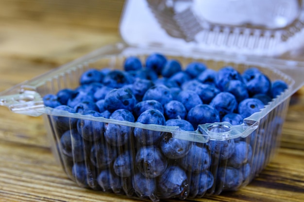 Blueberry in plastic box on a wooden table