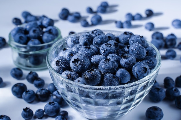 Blueberry with water drops Blue berries in glass plate on white background Many natural organic blueberries