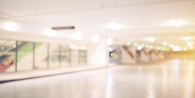 Blur image of empty car park in basement of garage shopping mall Defocused interior background concept