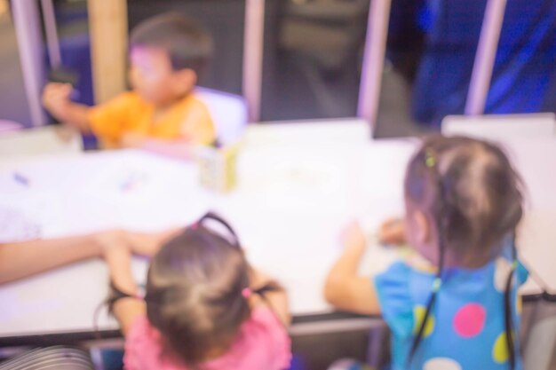 Blur image Little girl drawing at table