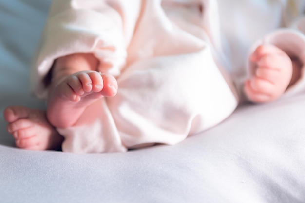 Blur images foot of baby newborn is 7dayold is lying on the bed to children and newborn concept