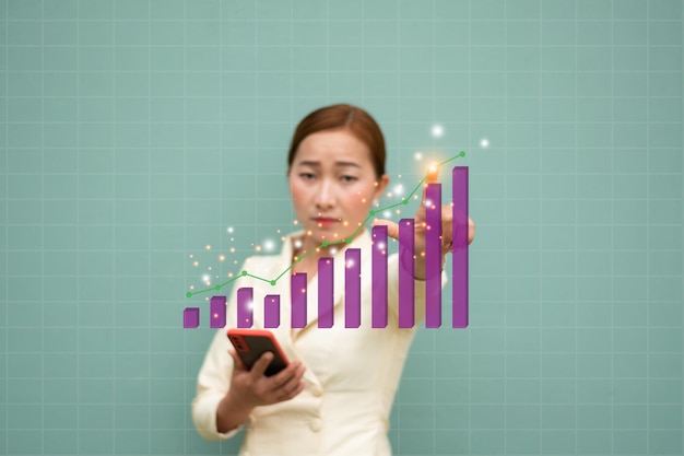 A blur women holding smartphone and touch pink business graph with graphic light trading and business concept