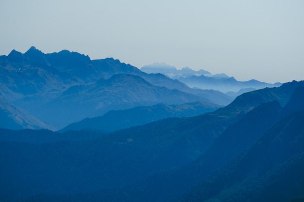 Blurred abstract natural background with Caucasus Mountains in a morning blue mist