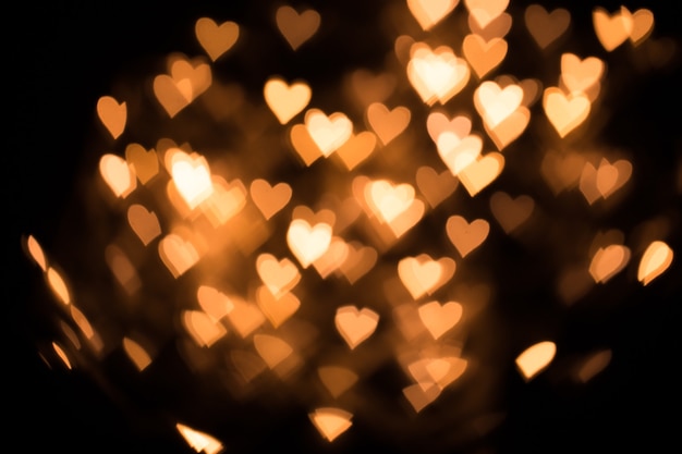 Blurred background, bokeh in the form of a heart of yellow warm color.