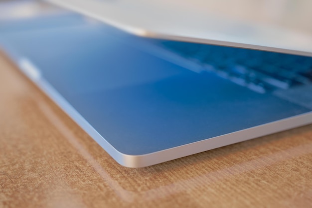 Blurred background of a laptop on a table in a coworking space the screen glows blue splash screen or background for a banner about networking or programming