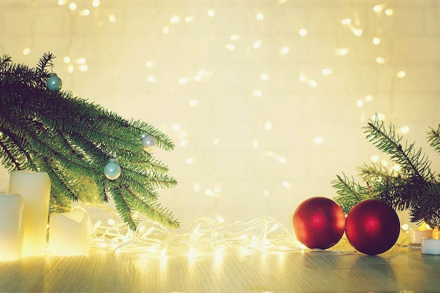 Blurred background with garland of red balls and fir branches for christmas and new year collage.