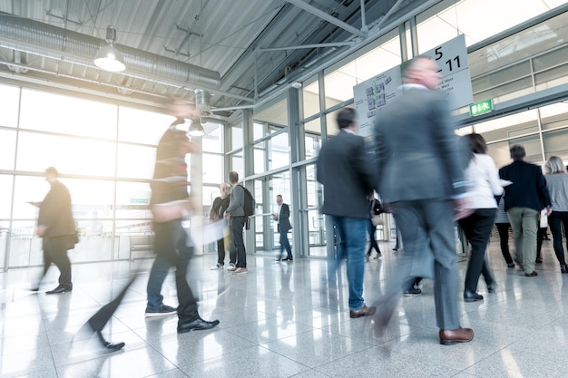 Blurred business people at a trade fair entrance