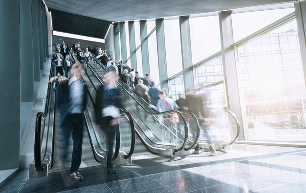 Blurred commuters rushing on escaltors in a  trade fair. ideal for websites and magazines layouts