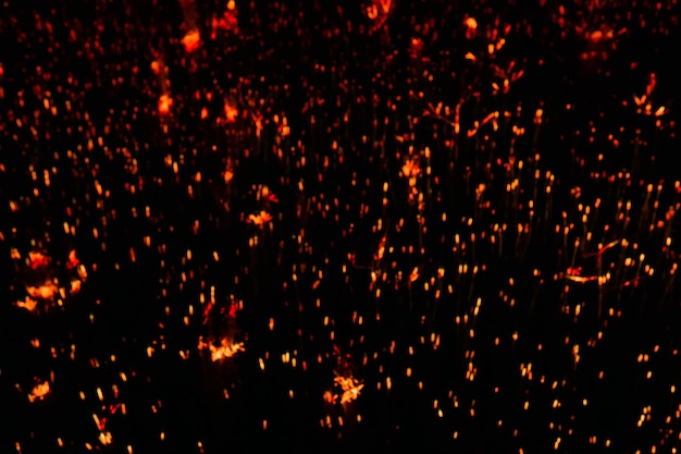 Blurred dark background - orange sparks in the darkness