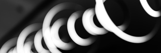 Blurred hanging lamp bulb in the form of rings blur abstract lighting modern pendant electricity round lamps chandelier glowing gray dim light inside a room tinted in black and white banner