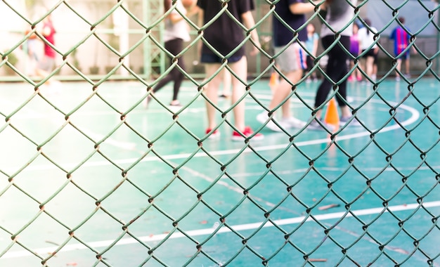 Blurred image of a stadium with people playing basketball.