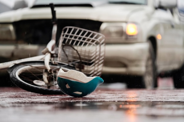 Blurred image of a traffic accident helmet and bicycle after a car crashes into a cyclist on the road during heavy rain spot focus