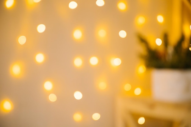 Blurred lights of a Christmas garland. The light is yellow. Festive background and texture.