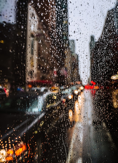 Blurred New York City street background with waterdrops, lights and cars at raining evening time