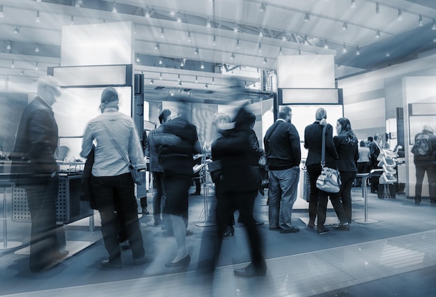 blurred people crowd on a exhibition with trade fair booths. copyspace for your individual text.