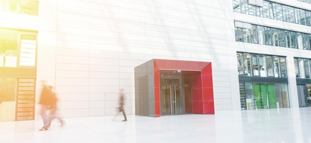 Blurred people go through hall in business office