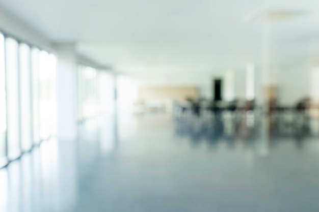 Blurred photo of empty room or office with sunlight from window. Abstract background.