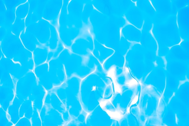 Blurred transparent blue colored clear calm water surface texture with splashes and bubbles Trendy abstract nature background Water waves in sunlight water background