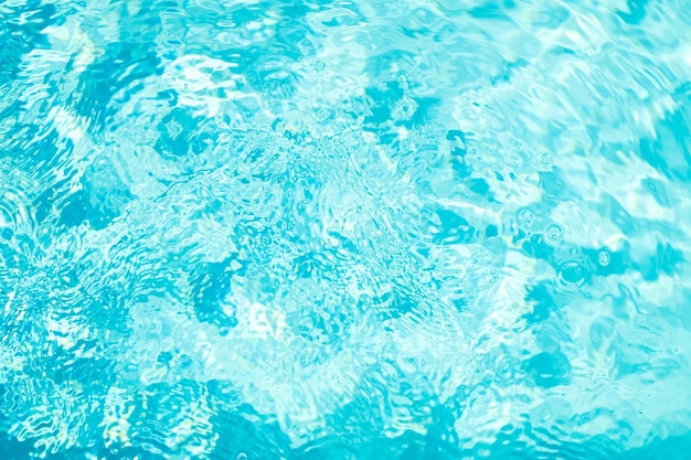 Blurred transparent blue colored clear calm water surface texture with splashes and bubbles Trendy abstract nature background Water waves in sunlight water background