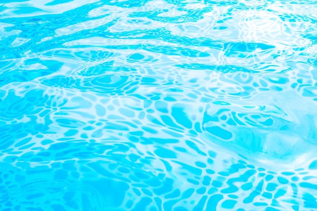 Blurred transparent blue colored clear calm water surface texture with splashes and bubbles