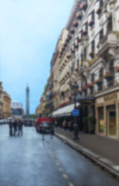 Blurred view of Paris street with shops, people and buildings.