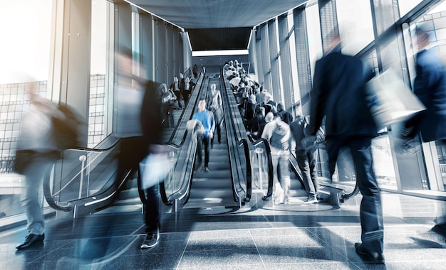 Blurred visitors rushing on escaltors at a tradeshow. ideal for websites and magazines layouts