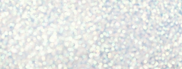 Blurred white background with circle sparkling lights Shiny brilliant glittery bokeh of christmas garland Silver multicolored backdrop