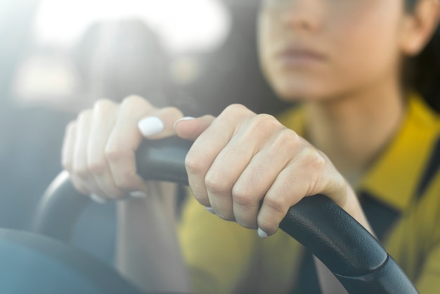 Blurred woman holding her hands on the steering wheel