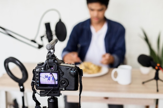 Blurry image of Asian young man prepare for food vlogging using broadcasting equipment