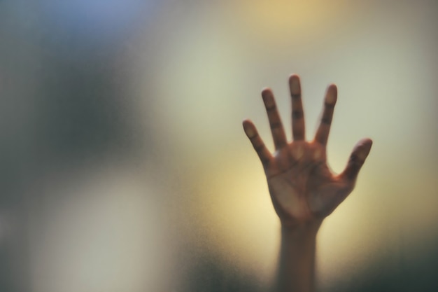 Blurry shadow hand of the man behind frosted glass