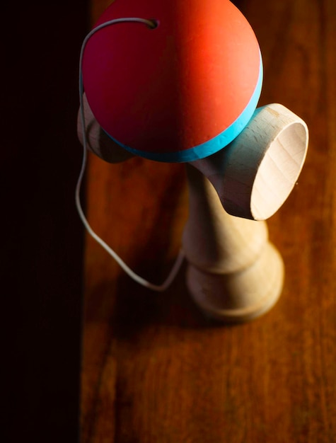 Blurry shape of kendama Japan toy on wooden board selective focus