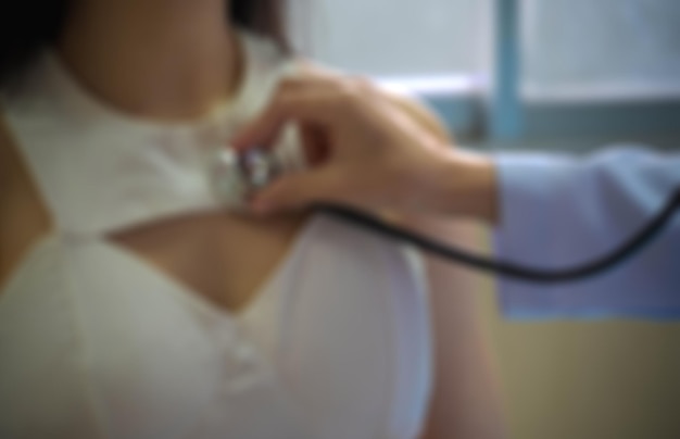 Blurry and soft of doctor examining patient lungs using stethoscope at hospital and clinic