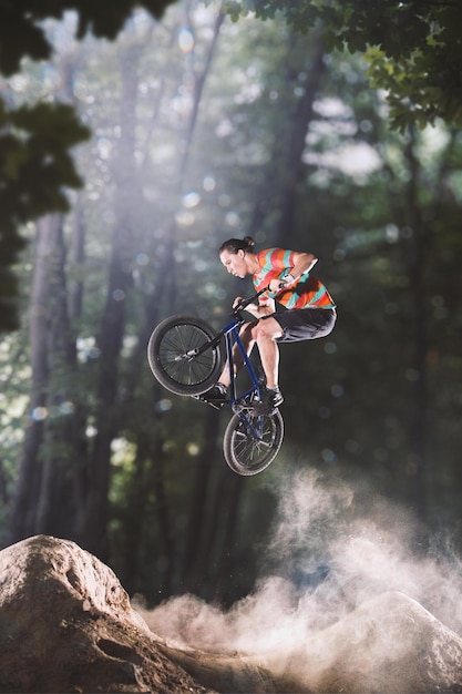 Bmx bicycle rider tricking on the forest hills