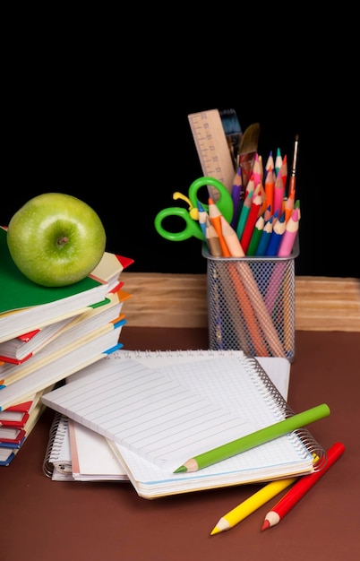 board books pencils opened empty notebook against a dark background