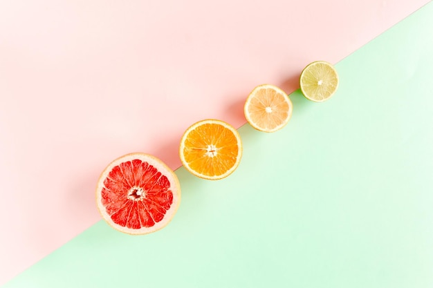 Board frame and summer tropical fruits orange lemon lime mango on pink background food concept flat