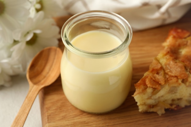 Board with pie and condensed milk, close up