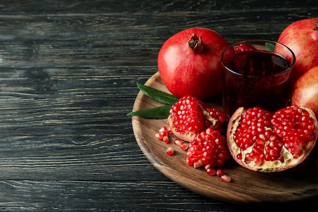 Board with pomegranate juice and ingredients on wooden table