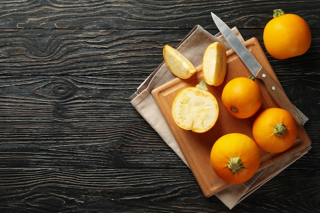 Board with zucchini, knife and towel on wooden 