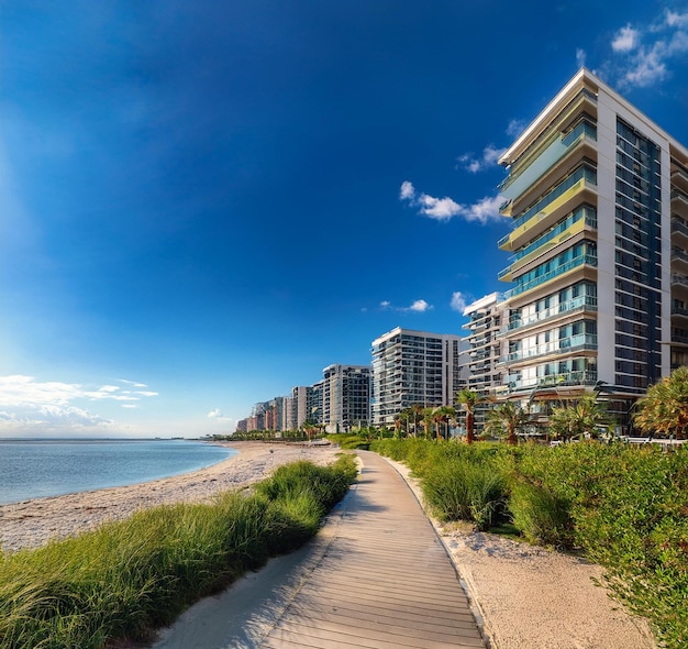 Photo a boardwalk leads to a beach with a building on the right side