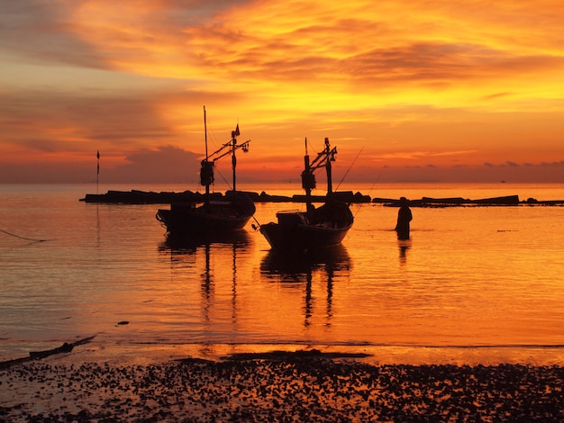 Boat on the beach at sunrise in tide time