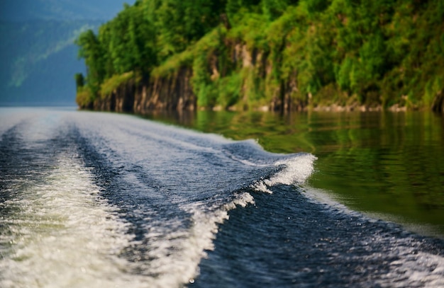 The boat cuts the surface of the lake water of lake teletskoye altai republic russia