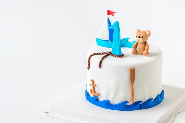 Boat and doll bear fondant on vanilla cake on white background