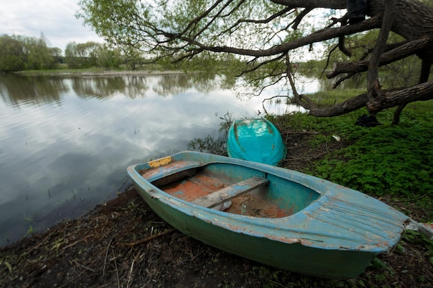 the boat lies on the banks of the river in the summer village