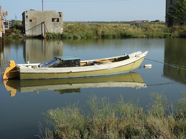 Boat moored in lake against sky