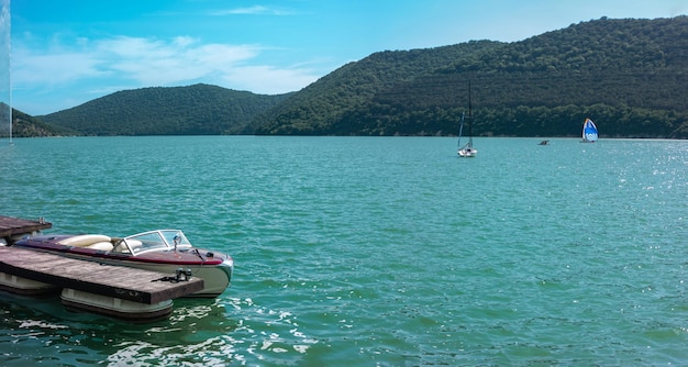 Boat moored at the pier on the emerald water of the mountain lake AbrauDurso