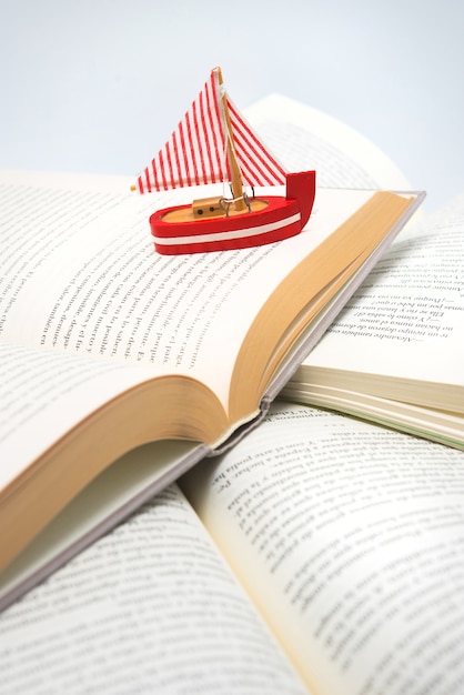 Boat navigating between books, traveling, reading, adventures in books