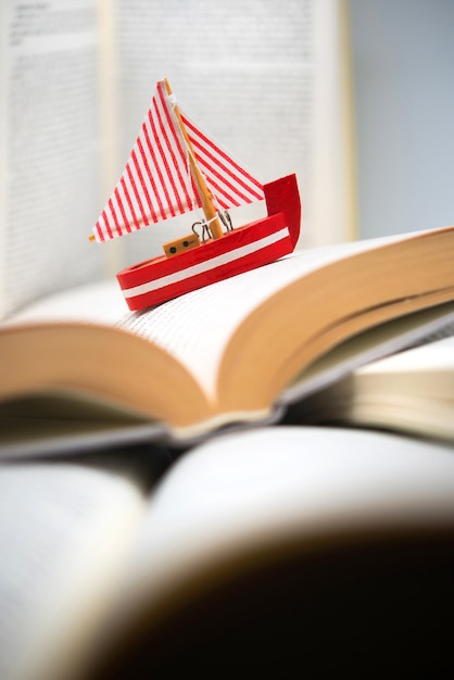 Boat navigating between books, traveling, reading, adventures in books