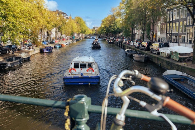 Photo boat sails along the canal in amsterdam, netherlands.