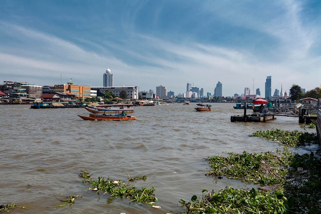 Boats on the Chao Phraya River and high-rise buildings in Bangkok.