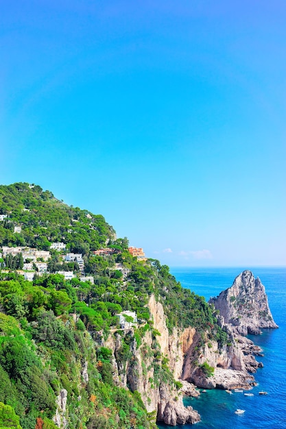 Photo boats at faraglioni cliffs and tyrrhenian sea of capri island, italy